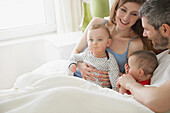 Pärchen im Bett mit Baby-Zwillingen