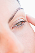 Extreme Nahaufnahme einer Frau, die ihren Augenwinkel berührt