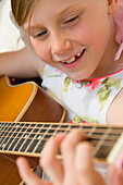 Niedliches junges Mädchen spielt Gitarre