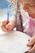 Mädchen malt auf Keramikteller