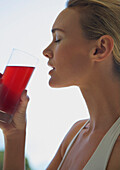 Close up  profile of a woman drinking cranberry juice