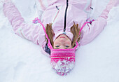 Mädchen mit rosa Wollmütze im Schnee