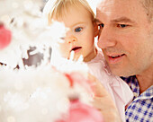 Vater und kleine Tochter mit Blick auf den Weihnachtsbaum