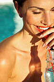 Smiling Woman Drinking with Straw, Close-up View