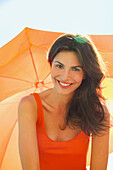 Smiling Woman Under Orange Parasol