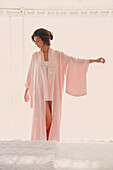 Woman Wearing Pink Kimono Standing with Hand Raised