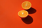 Halbierte Orange auf orangem Hintergrund