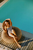 Frau entspannt sich am Swimmingpool, hoher Blickwinkel