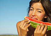 Junge Frau isst eine Wassermelone