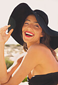 Lächelnde junge Frau, die einen Hut mit breiter Krempe trägt