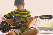 Junge spielt Gitarre