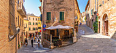 Blick auf ein Café und eine Bar in einer engen Straße in Montepulciano, Montepulciano, Provinz Siena, Toskana, Italien, Europa