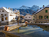 Ein Platz und ein Brunnen im Alpendorf Sent im Winter, Sent, Schweiz, Europa