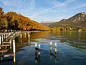 Berge und Herbstfarben an der Uferpromenade des Annecy-Sees, Annecy, Haute-Savoie, Frankreich, Europa