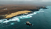 Luftaufnahme der wilden Küstenlinie mit Basaltbecken an der Atlantikküste, Dombe Grande, Namibre, Angola, Afrika