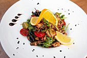 Teller mit Oktopus-Salat mit Oliven und Cherrytomaten, Pula, Kroatien, Europa