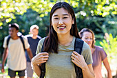 Young adult woman looking at the camera while hiking with friends
