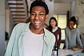 Front view portrait of young adult man laughing while looking at the camera