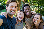 Selfie-Aufnahme einer Gruppe von Freunden, die sich nach einer Wanderung im Wald umarmen