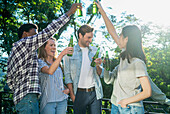 Group of friends toasting with beer bottles standing outdoors