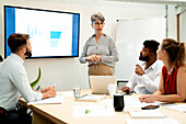 Businesswomen doing a presentation to colleagues at conference room