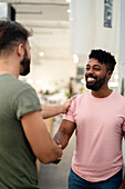 Coworkers shaking hands while standing in office