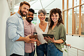 Group of coworkers looking at the camera while standing in hallway