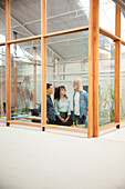 Group of coworkers talking while standing in meeting room