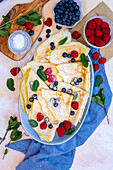 Crepes topped with raspberries, blueberries and fresh mint served on a large oval plate.