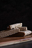 Slices of Indonesian style fermented tempeh against a dark background, with negative copy space.