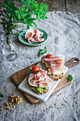 Avocado und Schinken auf Toast mit Tomate