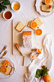 Orangen-Madeira-Kuchen mit Sirup und Orangenschalen. Tischdekoration für den Nachmittagstee Flatlay