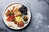 Italienische Snacks Essen mit Schinken, Oliven, Käse, Trauben, Wurst und Brot auf konkreten Hintergrund Kopie Raum