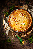 A sausage pie made with shortcrust pastry and decorated with pastry letters spelling oink oink oink.