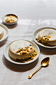 Panna cotta with passion fruit, served on a plate with a golden spoon