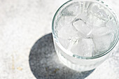 Von oben betrachtet ein Glas reines Wasser mit Eiswürfeln an einem heißen Sommertag