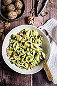 Pasta with broccoli and walnut pesto in a bowl on a wooden table