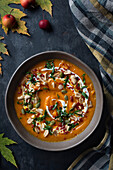 Pumpkin cream soup with seeds, nuts and yoghurt. View from above