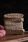 Slices of Indonesian-style fermented tempeh against a dark background