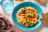 Chickpea hummus and galettes on a blue plate.