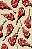 Vertical pattern of raw fresh meat tomahawk steak on beige background flatlay food