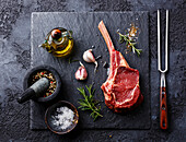 Raw fresh veal rib steak with bone and spices on a dark background