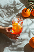aperol spritz, cocktail, on a linen tablecloth, shadows, hard sunlight, summer drink in glass
