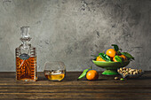 Bourbon in einer alten Karaffe und einem Eisglas mit einer Schale Mandarinen und einer Schale Pistazien