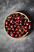 Cherries in a Bowl on a dark grey background