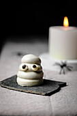 Ghost sweet over table for Halloween; made with cookie, dulce de leche and white chocolate coating