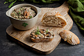 A bowl of mushroom pie, a sandwich and a piece of bread on a chopping board