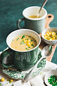 Corn Chowder served in a green mug with sweetcorn