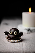 Bat sweet over table for Halloween; made with cookie, dulce de leche and dark chocolate coating