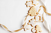 Weihnachtsplätzchen mit Zuckerguss auf weißem Hintergrund mit Schleife